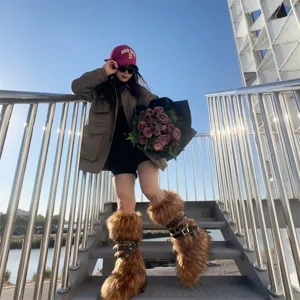 Stylish model wearing Y2K punk style faux fur snow boots with stud straps on metal stairs