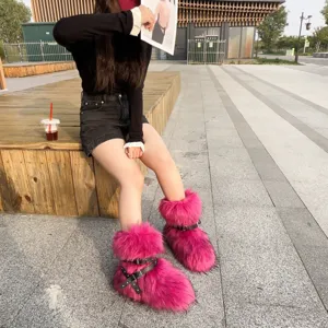 Outdoor street style shot of bright pink Y2K faux fur boots with black rivet straps