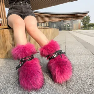 Close-up of hot pink faux fur snow boots with punk style black buckle straps