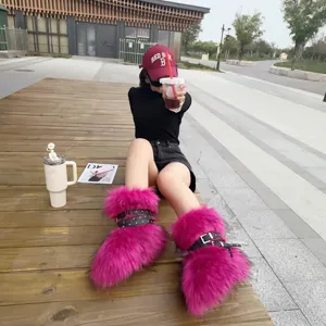 Detail view of hot pink faux fur Y2K boots with studded straps on an outdoor model