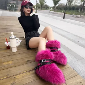 Close-up detail of bright pink Y2K faux fur snow boots with punk rivet buckles and straps