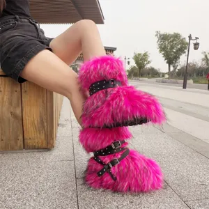 Close-up of vibrant neon pink faux fur Y2K boots with black studded buckle straps.