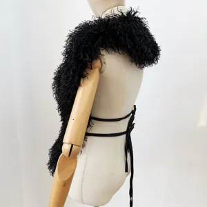 Zijaanzicht met textuur en bandjes van de zwarte gekrulde haltertop van imitatiebont