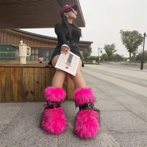 Stylish oversized hot pink faux fur snow boots featuring punk black buckles and silver rivets