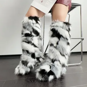 Detail shot of Y2K faux fur knee-high snow boots in black and white pattern