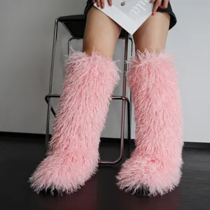 Gedetailleerd zicht op roze harige kniehoge laarzen van imitatiebont met interieurachtergrond