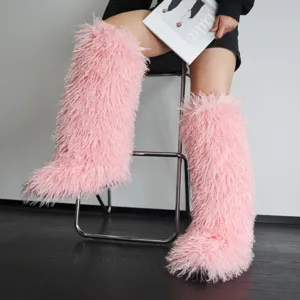 Detailweergave van de zachte, pluizige textuur van roze kniehoge laarzen van imitatiebont
