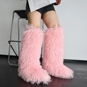 Detail van de pluizige textuur van roze imitatiebont kniehoge sneeuwlaarzen