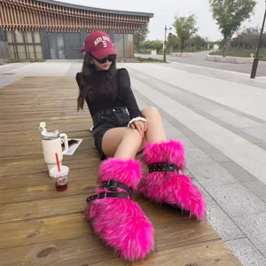 Detail of vibrant pink faux fur Y2K platform boots with black buckle straps