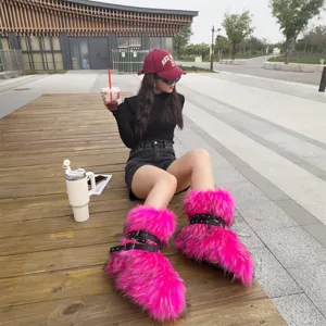 Detailed view of Y2K style vibrant pink faux fur boots with black studded straps.