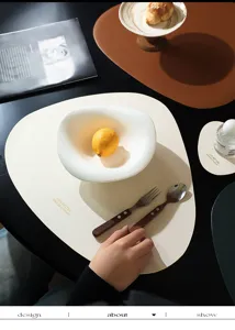 Primo piano di tovaglietta irregolare in pelle color crema con posate moderne