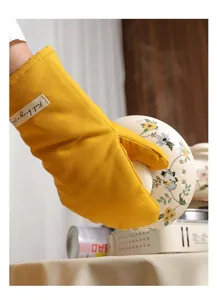 Dettaglio ravvicinato di un guanto da forno in cotone giallo spesso e termoisolante