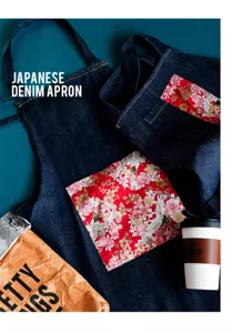 Detalle de delantal vaquero oscuro con bolsillos de flores y grullas japonesas.