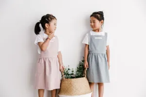 Vista de estilo de vida de dos niños con delantales de algodón de estilo japonés en rosa y azul