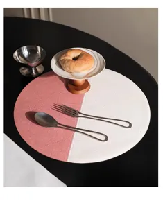 Dettaglio tovaglietta rotonda in ecopelle con elegante design bicolore rosa e bianco