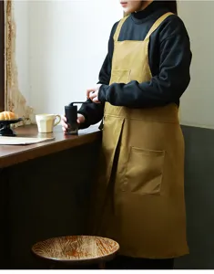 Barista professionista con grembiule da lavoro giallo senape in un ambiente rustico da bar.