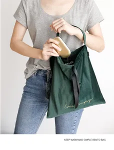Borsa bento termica in velluto verde scuro in uso con ricamo dorato fine