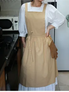 Primer plano de un elegante delantal de algodón beige plisado con bolsillos para hornear en cocina
