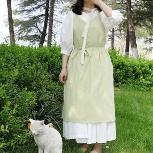 Grembiule in cotone verde chiaro rinfrescante da donna in giardino con gatto