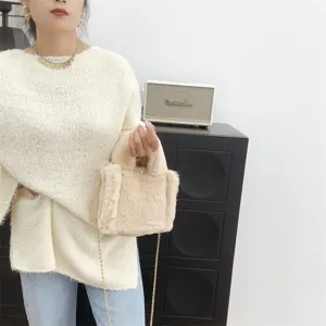 Primer plano de un mini bolso de piel sintética beige con elegante correa de cadena.
