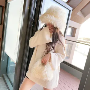 Model wearing a cozy cream faux sheep wool bucket hat and matching plush handbag set