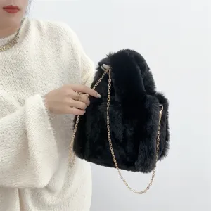 Primer plano de mini bolso tote de piel sintética negra con elegante cadena de oro