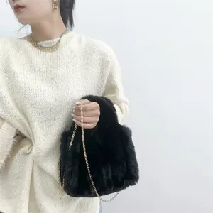 Primer plano de un mini bolso tote negro de piel de conejo sintética con cadena