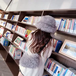 Rear view of a fuzzy grey bucket hat and matching plush crossbody bag in a library