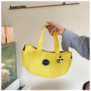 Detailansicht der gelben bananenförmigen Segeltuchtasche mit süßer Cartoon-Stickerei