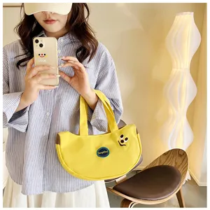 Detailansicht einer niedlichen gelben Bananen-Stofftasche mit lustiger Cartoon-Stickerei.