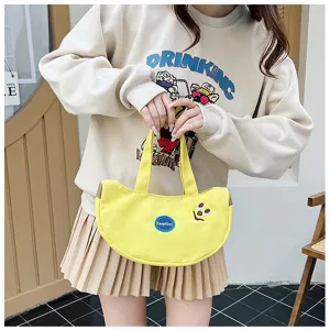 Detail der süßen gelben Bananen-Stofftasche mit Cartoon-Stickerei, von Model gehalten