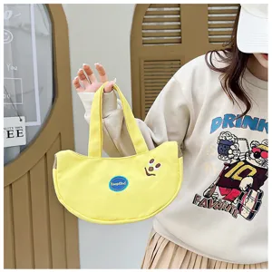 Detailansicht einer süßen gelben Leinwandhandtasche in Bananenform mit Cartoon-Stickerei