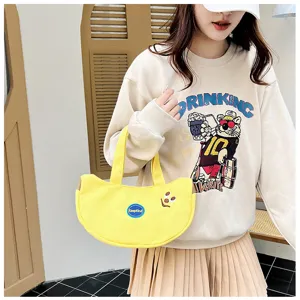 Detailliertes Lifestyle-Foto einer süßen gelben Bananen-Handtasche aus Canvas mit Stickerei