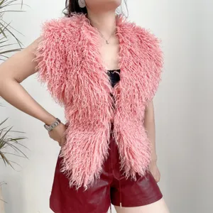 Detail van een roze imitatie Mongoolse lamswollen haltervest met bordeauxrode leren shorts.