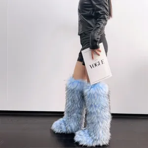 Close-up of fluffy blue and white faux fur knee-high Y2K style snow boots on model