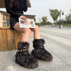 Outdoor lifestyle shot of black punk-style faux fur snow boots with silver buckles