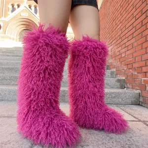 Detailopname van magenta imitatiebont kniehoge sneeuwlaarzen op een stenen buitstrap