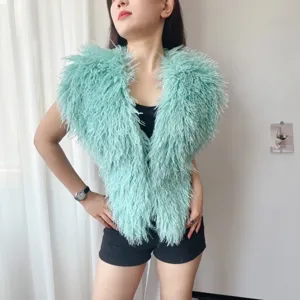 Detail van het harige turquoise Mongoolse imitatiebont vest met halternek op model