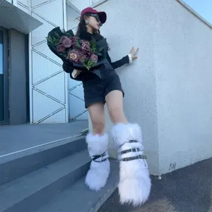 Y2K punk style white faux fur platform snow boots with black buckle straps worn by model