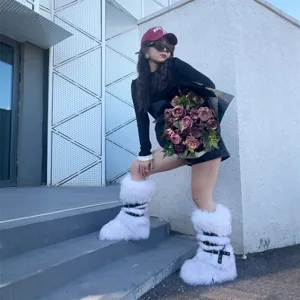 Stylish model wearing white Y2K punk faux fur snow boots with black buckled rivet straps