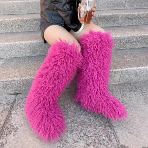 Trendy fuchsia felle kniehoge laarzen van imitatiebont op stenen trappen