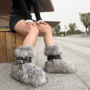 Detailed view of fluffy grey faux fur snow boots with studded black leather straps