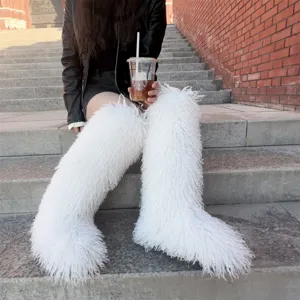 Stijlvolle witte kniehoge laarzen van imitatiebont in een trendy buitenomgeving stijl
