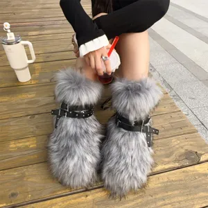 Close-up detail of Y2K style grey faux fur snow boots with punk studded leather buckles