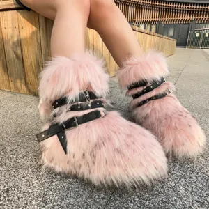 Pink Y2K style faux fur platform boots with black studded buckle straps worn by model.
