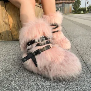 Detailed view of pink faux fur boots with black rivet leather buckles in Y2K style.