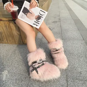 Close-up of pink faux fur snow boots with black studded buckles in Y2K style