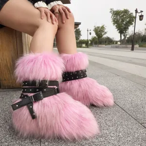 Pink Y2K faux fur boots with black studded buckle straps shown in an outdoor setting
