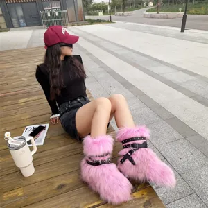 Detail view of Y2K pink faux fur snow boots with black studded punk straps on model