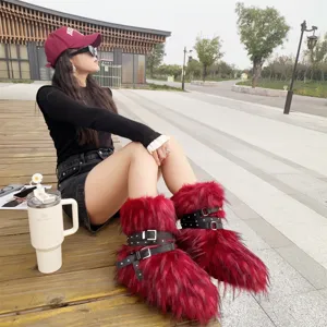 Trendy red Y2K faux fur punk snow boots with black rivet straps in outdoor lifestyle shot